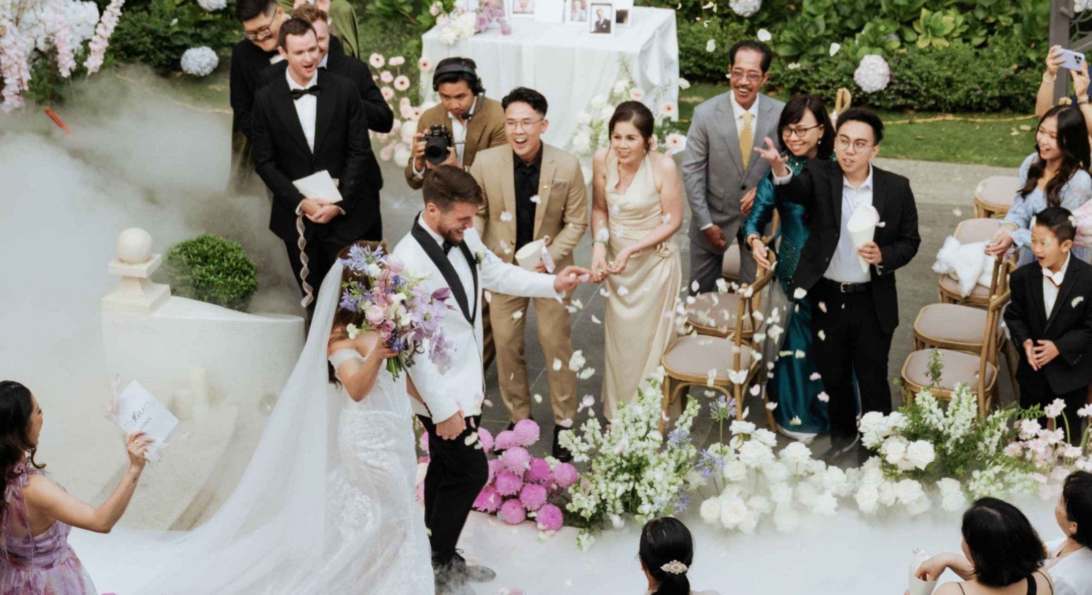 Guests tossing petals as the newlyweds walk down the aisle at Grand Mercure Dalat